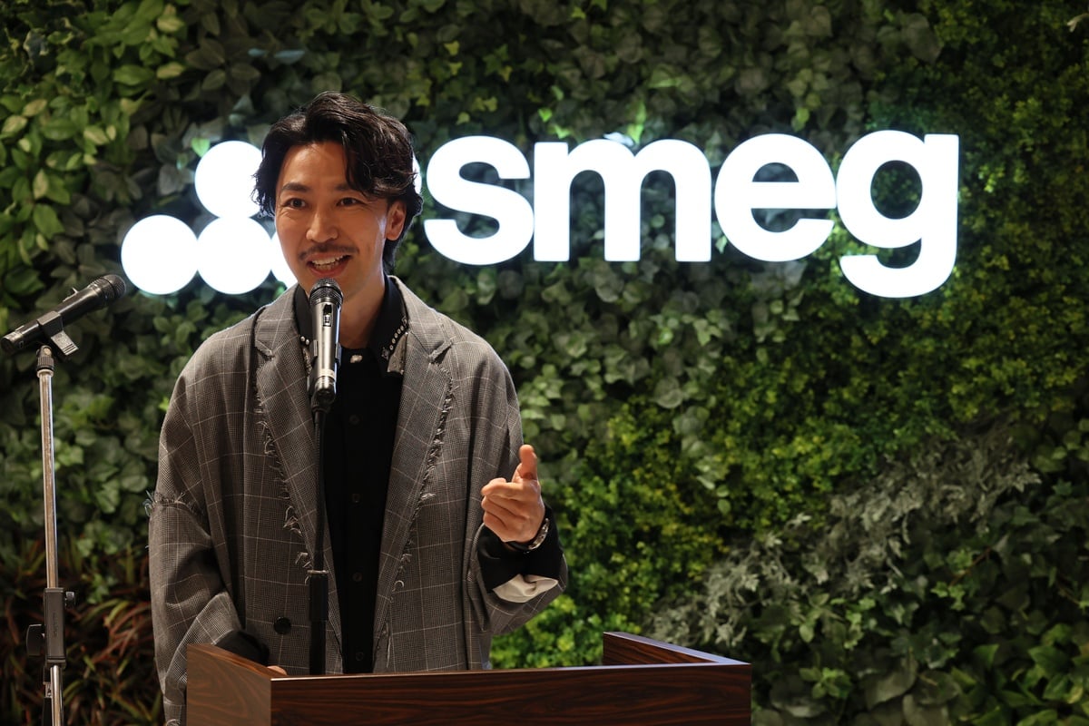 Smegのロゴを背景に登場したアンバサダーのTAKAHIRO氏。自身もSmegのケトルやトースター、小型冷蔵庫などを愛用していると語り、ブランドの魅力を発信していく