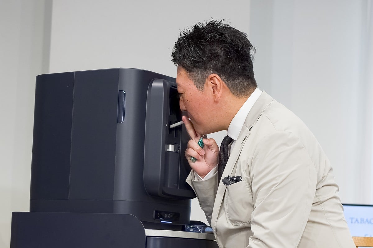 実際にSMOKE ZEROを体験するジャーナリストの堀潤氏。煙が空間へ拡散する前に吸い込まれるため、至近距離でもタバコ特有のにおいをほとんど感じなかった