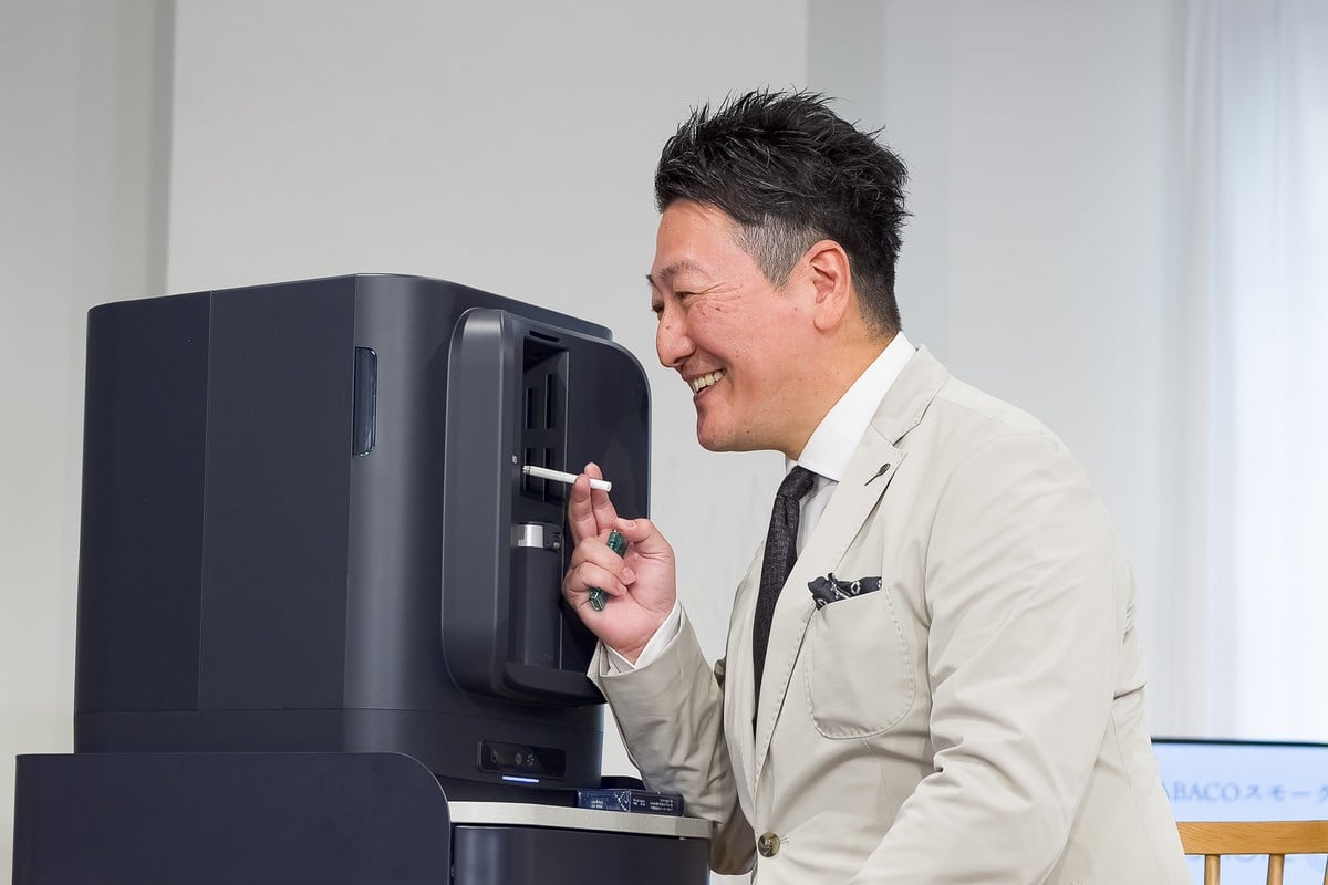 実際にSMOKE ZEROを体験するジャーナリストの堀潤氏。煙が空間へ拡散する前に吸い込まれるため、至近距離でもタバコ特有のにおいをほとんど感じなかった