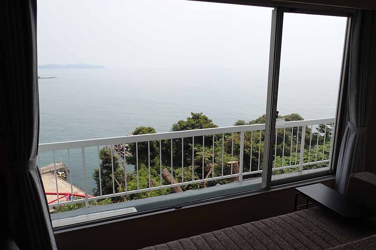 客室の多くはウインドーを広くとったオーシャンビュー。沖合に見えるのは初島だ
