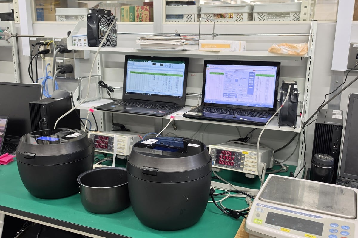 炊飯器と計測機器、PCが並ぶ評価環境。外観は大きく変わらなくても、米の状態や食のトレンドに合わせて、制御やソフトの部分は静かに見直されている