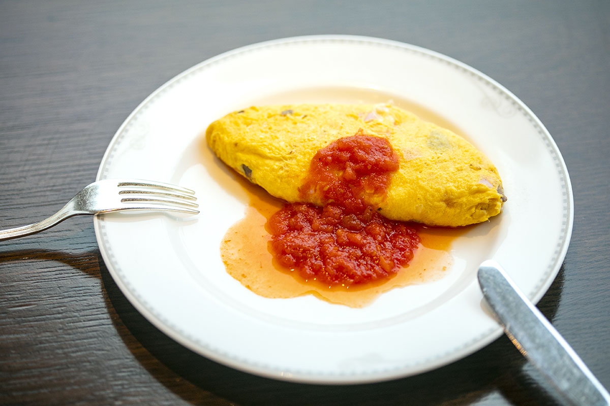 ほぼ噛まずに食べられる、ふわふわとろとろのオムライス。ケチャップではなく特製トマトソースをかけて
