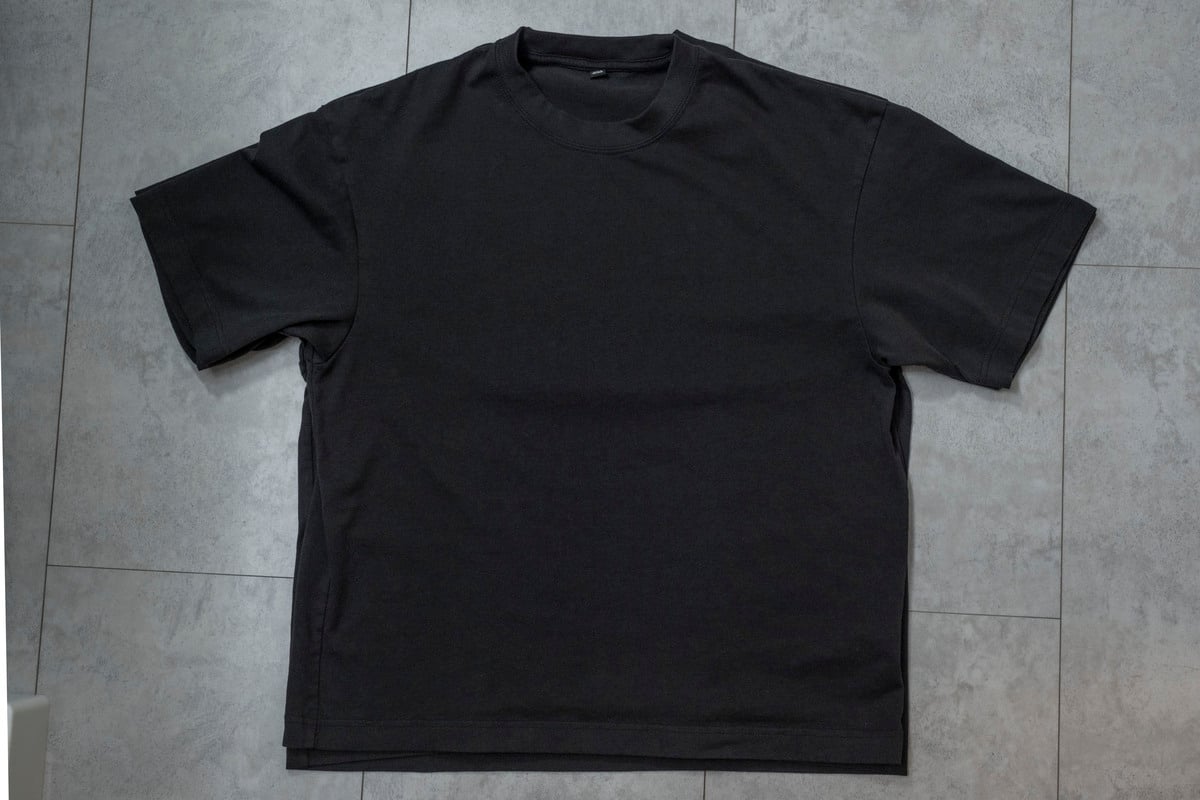 低温乾燥後の黒いTシャツと新品の同じTシャツを重ねて比較。裾にはわずかな縮みが見られたが、肩まわりや首まわりは大きく崩れず、普段着として十分着られる仕上がりだった