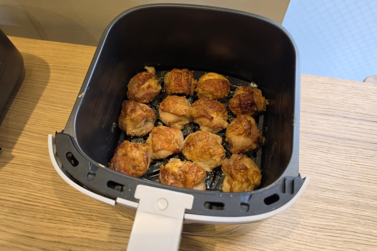 バスケットいっぱいに並べた唐揚げ。油を完全に使わないことを目的にせず、鶏もも肉500gにサラダ油小さじ1と水を加えるレシピで、健康性と衣の食感を両立させようとしている点にも、細かな検証の跡が見える