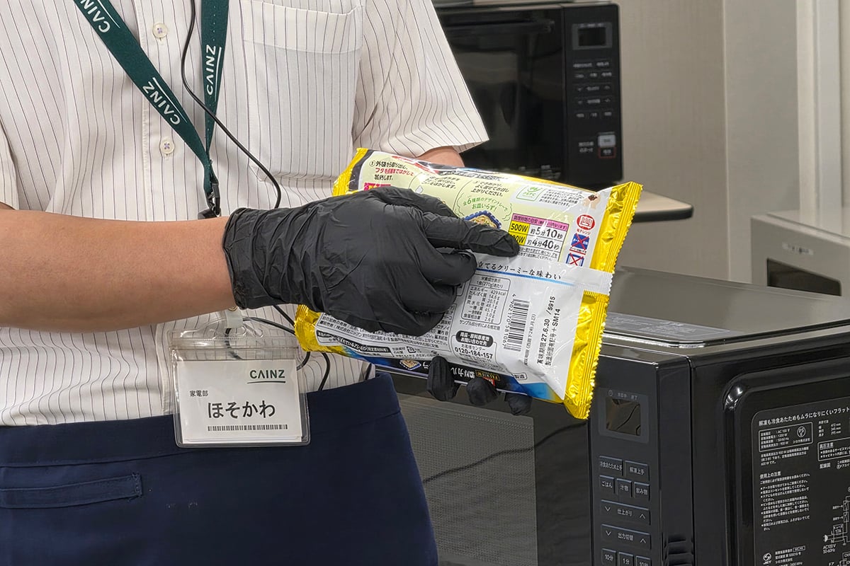 「冷食あたため上手」のデモで使われた市販の冷凍パスタ。パッケージには500W・600Wそれぞれの加熱時間が記載されているが、新製品ではこうした表示を毎回確認する手間を減らすことを狙う