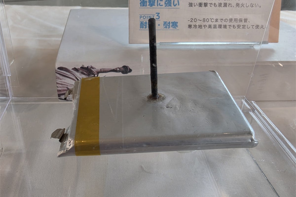 会場に展示されていた、釘を刺した状態の準固体電池セル。発表会では同社の試験条件下で発火しなかった結果が示された。安全性は試験条件と合わせて理解する必要がある。