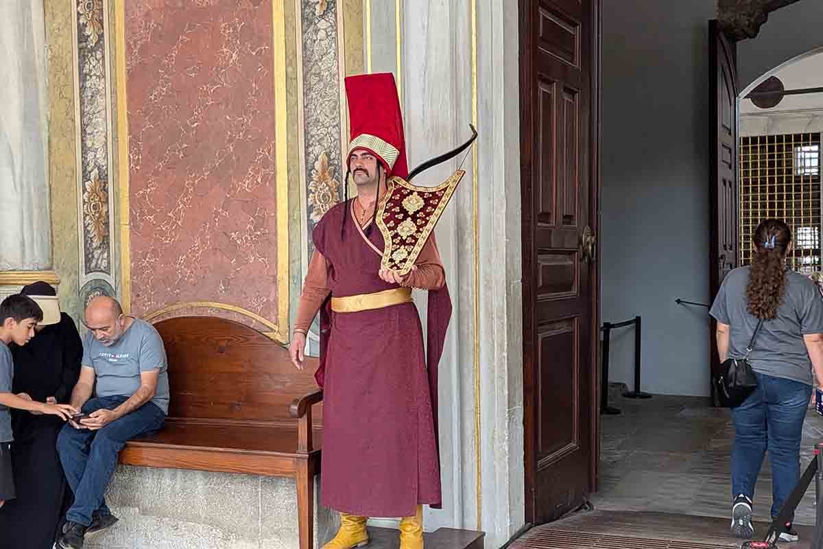トプカプ宮殿（Topkapı Palace）の敷地内で、オスマン帝国の精鋭歩兵軍団「イェニチェリ（Janissary）」の伝統的な装束を身にまとった護衛