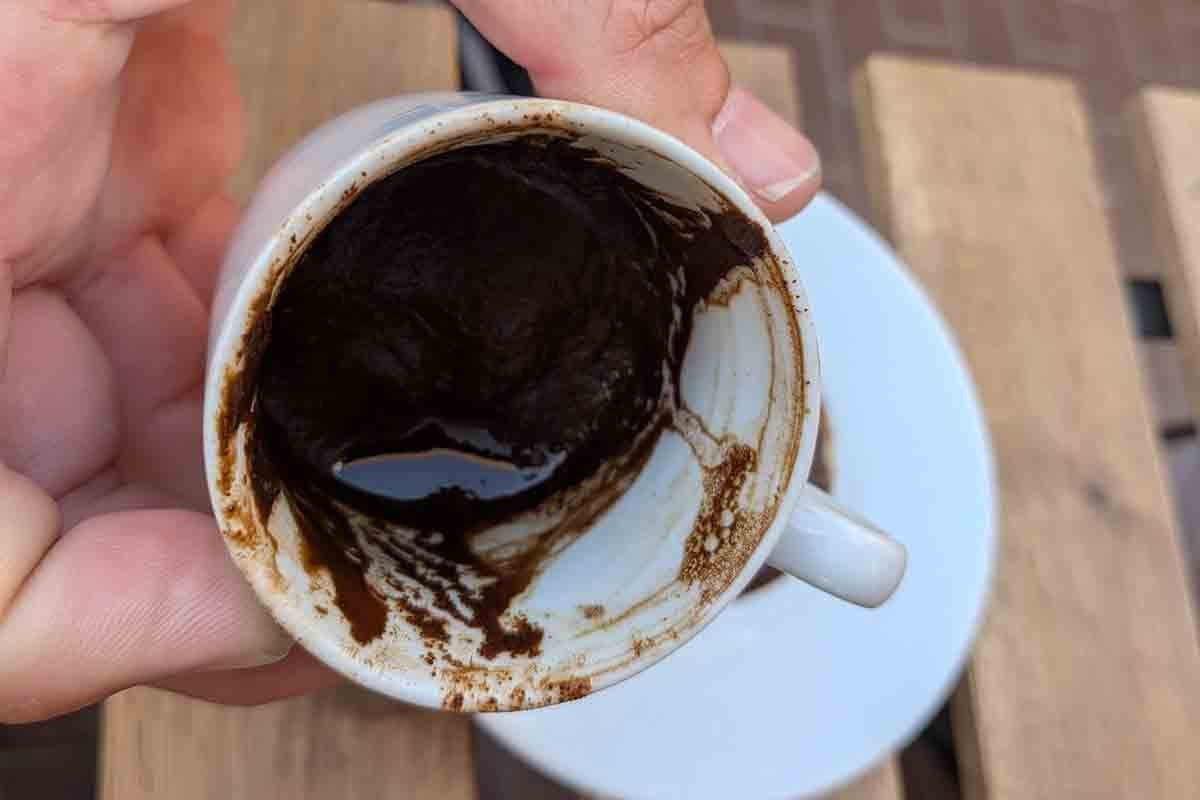 ターキッシュコーヒーでコーヒー占いをしている様子。ひっくり返して冷ました後のカップを持ち上げ、内側についた粉の垂れ筋や模様を観察、写真をチャットGPTに送れば結果が出る